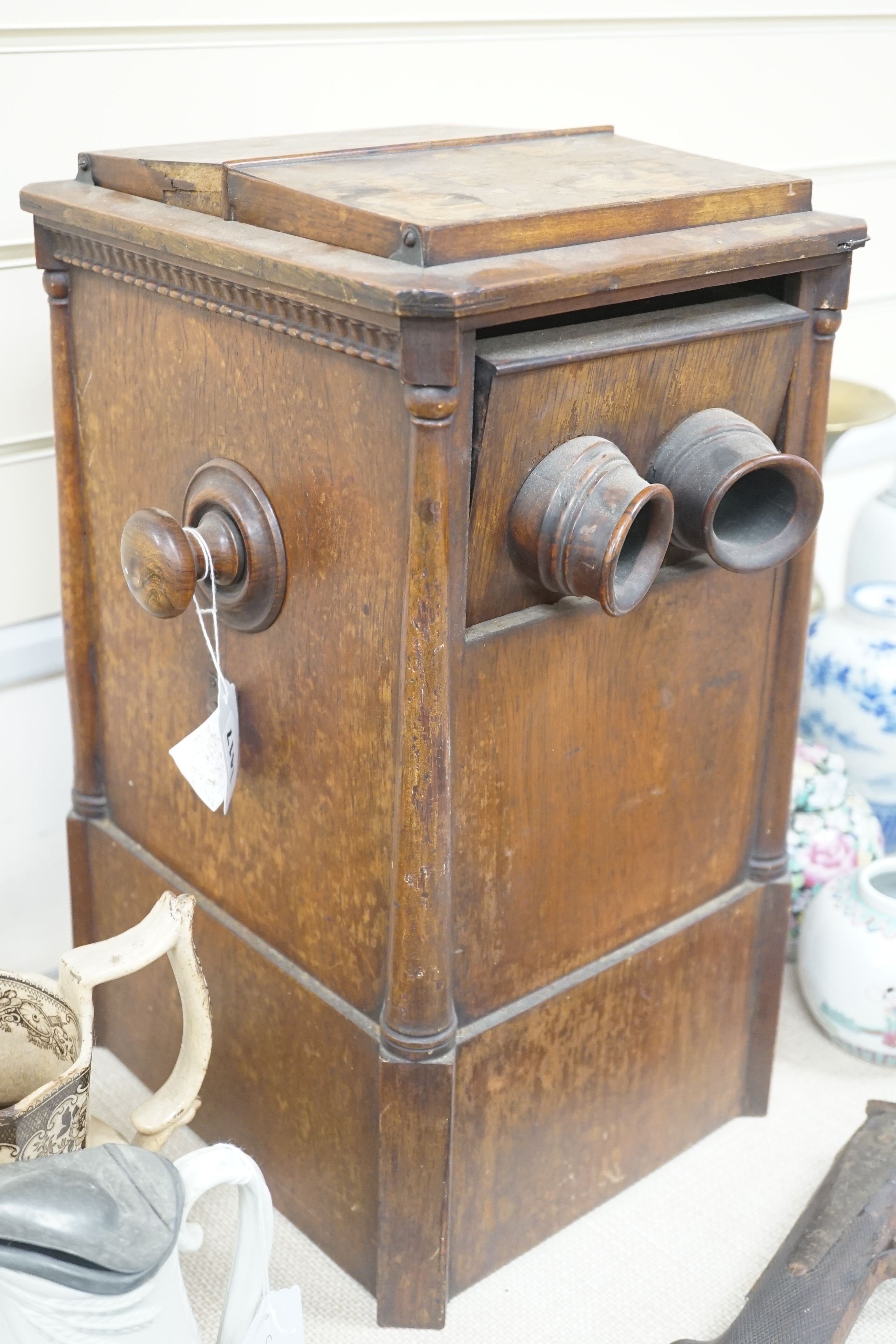 A late 19th century French walnut cased stereoscopic viewer, containing a quantity of stereographic photos, 46 cms high.